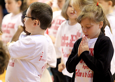 Jocelyn Brenot, 6, prays during Mass at John XXIII Catholic Elementary in Middletown Friday, April 25, 2014. The school held a special Mass to recognize the upcoming canonization of the school's namesake, Pope John Paul XXIII.