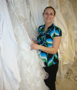 Cathy Diehl poses with wedding gowns that have been donated to her ministry. She makes burial garments for miscarried infants and babies that are stillborn or die at birth. (Courtesy Photo)
