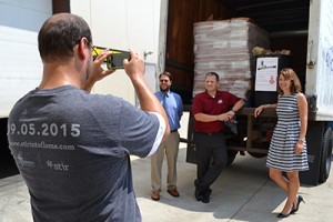 Sean Renyolds of the Archdiocese of Cincinnati takes a photo of the JTM Food Group donation. (CT Photo/John Stegeman)