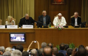 Pope Francis addresses a workshop on climate change and human trafficking attended by mayors from around the world in the synod hall at the Vatican July 21. Local government leaders were invited to the Vatican by the pontifical academies of sciences and social sciences to sign a declaration recognizing that climate change and extreme poverty are influenced by human activity. Also seen are, from left, Argentine model Valeria Mazza, serving as master of ceremonies; Bishop Marcelo Sanchez Sorondo, chancellor of the Pontifical Academy of Sciences; Cardinal Francesco Montenegro of Agrigento, Italy; and Cardinal Claudio Hummes, former prefect of the Congregation for the Clergy. (CNS photo/Paul Haring) 