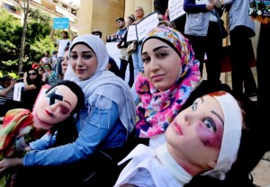 Protesters carry mannequins showing signs of domestic violence in Beirut May 30. Some synod observers said women should not to return to abusive husbands. (CNS photo/Nabil Mounzer, EPA) 