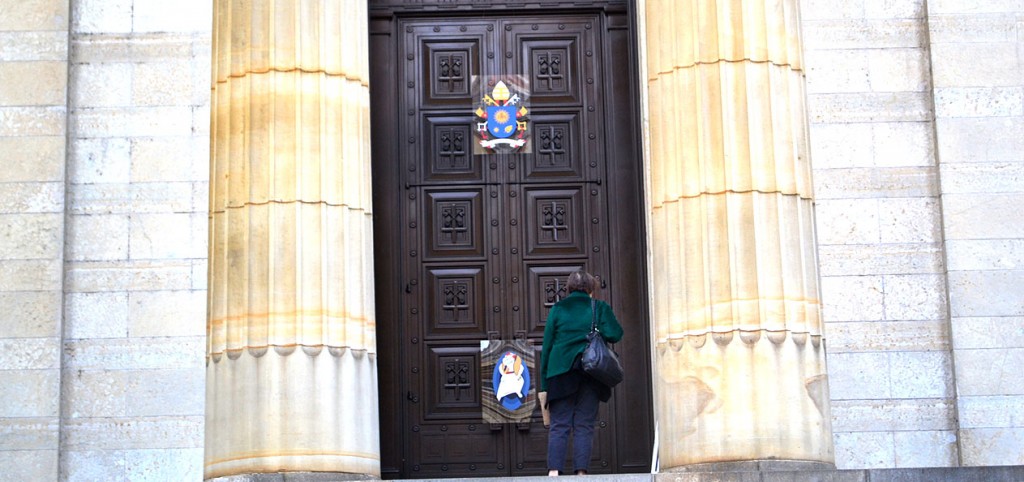 A woman examines the Holy Door of Mercy at the Cathedral of St. Peter in Chains in downtown Cincinnati. The holy door was sealed in a Nov. 1 ceremony. It will be opened in a ceremony by Cincinnati Archbishop Dennis M. Schnurr at the 11 a.m. Sunday Mass on Dec. 13. (CT Photo/John Stegeman)