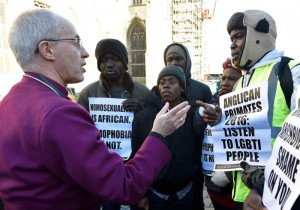 Anglican Archbishop Justin Welby of Canterbury, spiritual leader of the Anglican Communion, speaks with protestors on the grounds of England's Canterbury Cathedral, which was closed for a meeting of primates of the Anglican Church. At the meeting, Anglican leaders sanctioned Episcopalians over same-sex marriage. (CNS photo/Toby Melville, Reuters) 