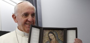 Pope Francis holds an image of Our Lady of Guadalupe aboard the papal flight to Brazil in this July 22, 2013, file photo. The pope is deeply devoted to Mary and visited the image of Guadalupe while in Mexico last week. (CNS photo/Paul Haring)