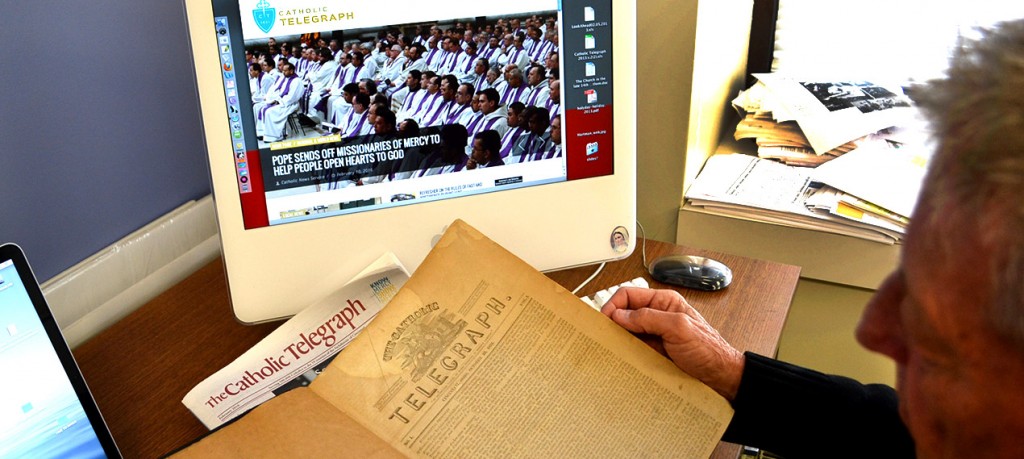 A visitor to The Catholic Telegraph offices compares the Oct. 22, 1831 edition of the newspaper to the current edition and website during Catholic Press Month 2016. (CT Photo/John Stegeman)