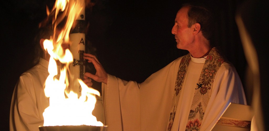 Father Robert Smith, pastor of St. James Parish in Setauket, N.Y., marks the paschal candle at the beginning of the Easter Vigil at his church April 19, 2014. (CNS photo/Gregory A. Shemitz, Long Island Catholic)