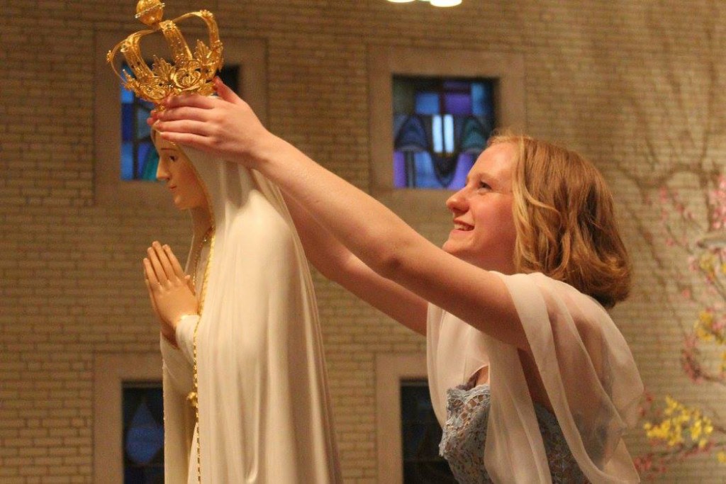 A St. Gertrude student crowns a statue of the Blessed Virgin during May Crowning 2016. (Courtesy Photo)