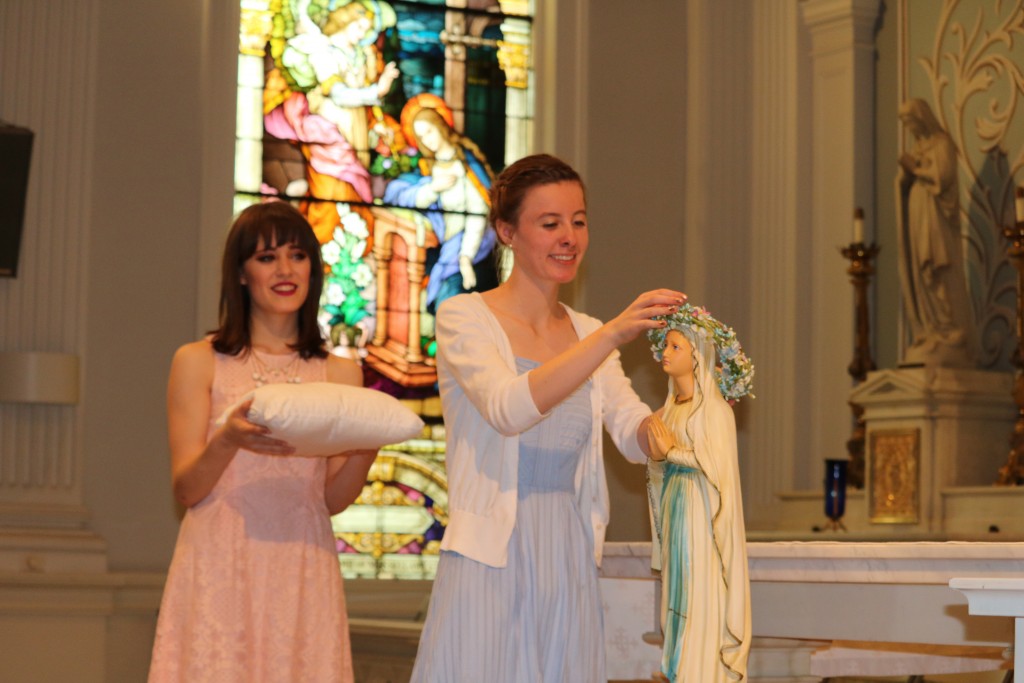 Saint Ursula Academy seniors Gabrielle Silvestri (left) and Sarah Tippenhauer (right) crowned a statue of the Blessed Mother Mary during a May Crowning ceremony in the Saint Ursula Academy chapel on April 29.