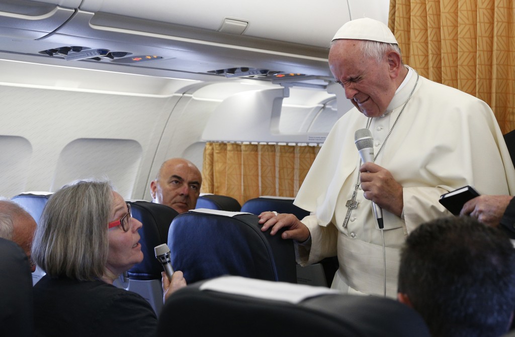 Pope Francis closes his eyes as he reacts to a question from Cindy Wooden, Catholic News Service Rome bureau chief, aboard his flight from Yerevan, Armenia, to Rome June 26. The pope reacted as Wooden mentioned the June 12 shooting that killed 49 at a nightclub in Orlando, Fla. 