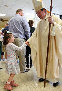 Sophie Kellogg, 5, shakes hands with Archbishop Dennis Schnurr after the Queen of Peace Catholic Church 75th Anniversary Mass on Sunday, October 2, 2016, in Millville, Ohio. (CT Photo/E.L. Hubbard)