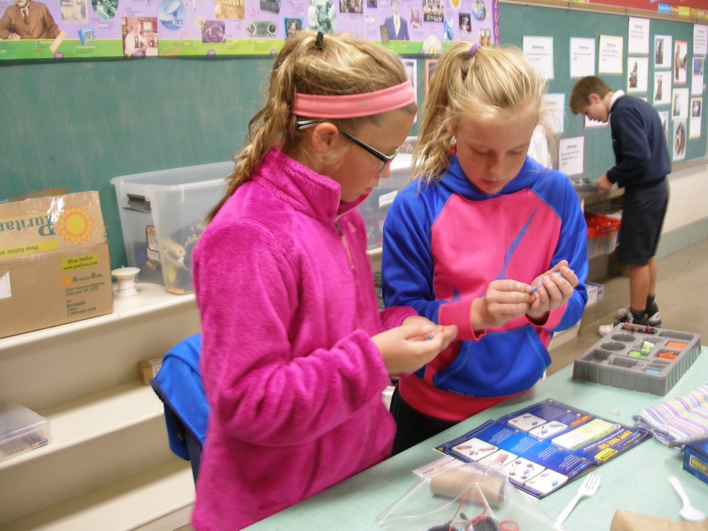 Our Lady of Lourdes students Bella Maxfield and Emily Smith create a car using a circuitry kit, cardboard tube and assorted items. (Courtesy Photo)