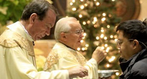 The Catholic Telegraph/E.L. Hubbard Archbishop Dennis Schnurr and Rev. Louis Gasparini give Holy Communion during Day of Prayer for World Justice and Peace at Saint Peter in Chains Cathedral in Cincinnati Wednesday, January 1, 2014.