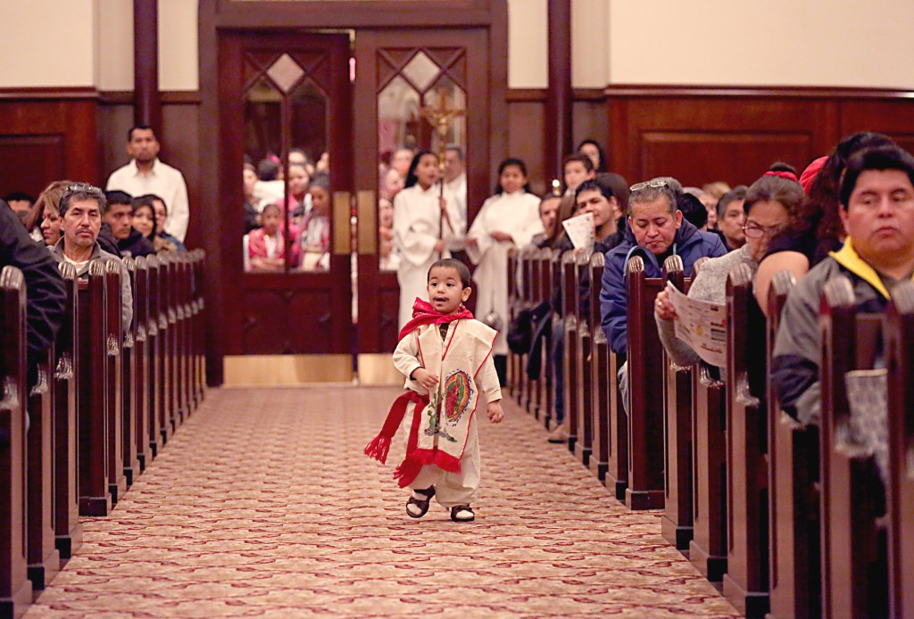 A young boy, dressed as Saint Juan Diego, runs down the aisle during the Feast of Our Lady of Guadalupe at St. Julie Billiart parish in Hamilton Sunday, Dec. 11, 2016. The Day of Prayer was to focus on the plight of refugees and migrants across the United States. (CT Photo/E.L. Hubbard)