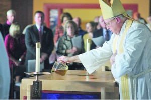 Bishop Binzer consecrates the altar with blessed oil. (CT Photo/ Jeff Unroe)