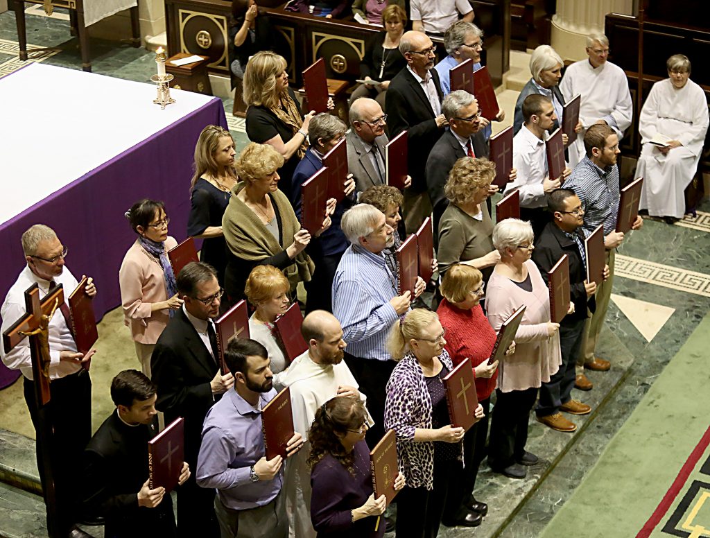 Parish catechists hold the Book of the Elect during the Rite of Election of Catechumens and of the Call to Continuing Conversion of Candidates who are preparing for Confirmation and Eucharist or Reception into Full Communion with the Roman Catholic Church at the Cathedral of St. Peter in Chains in Cincinnati Sunday, Mar. 5, 2017. (CT PHOTO/E.L. HUBBARD)