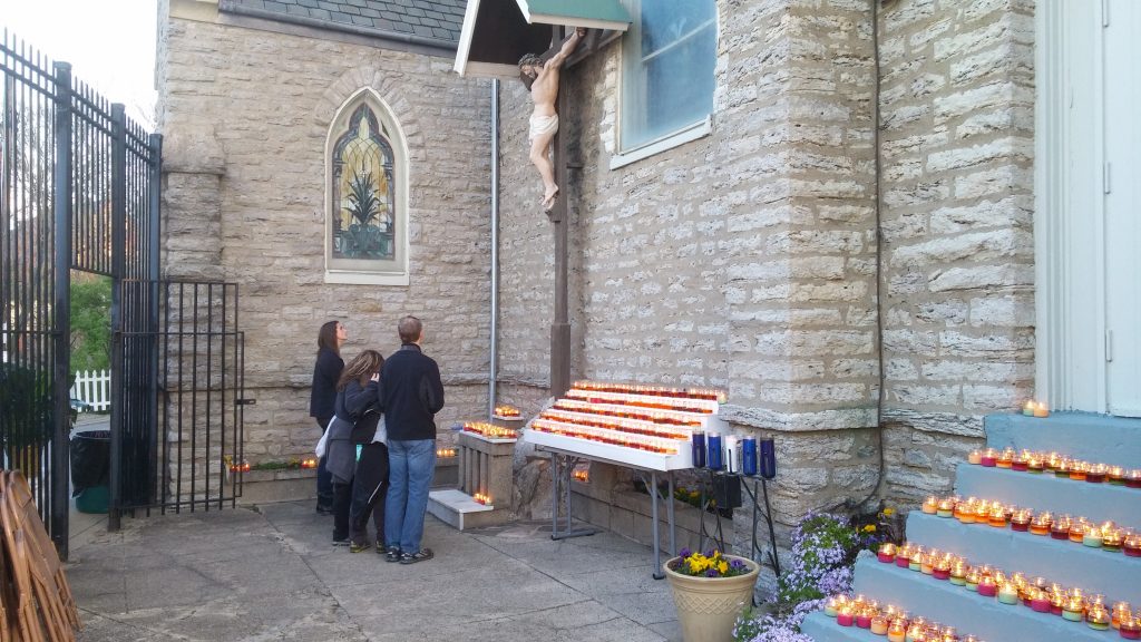 A family prays at the foot of the outdoor cross at Holy Cross Immaculata. (Greg Hartman/CT Photo)