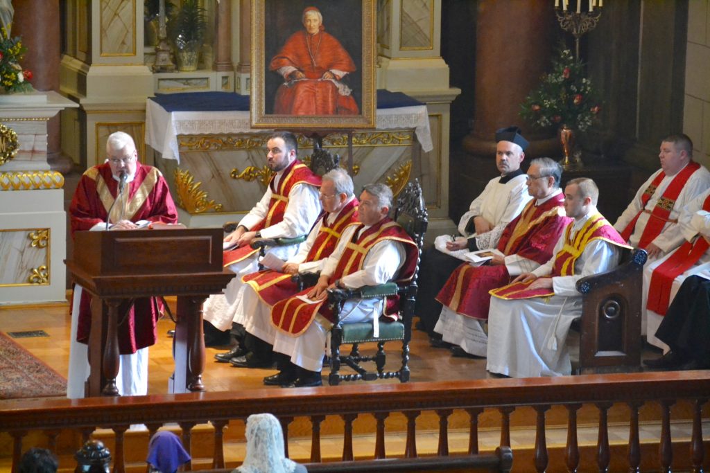 Msgr. Frank Lane delivered the homily. To his right are some of the concelebrating priests, including the representatives from Rome and the Cincinnati Oratory priests. Also pictured: Fathers James Reuetter and Matt Feist. The painting depicts Bl. Cardinal John Henry Newman, an Oratorian and one of the leading figures of the 19th century English Catholic revival. (CT/Photo by Gail Finke)