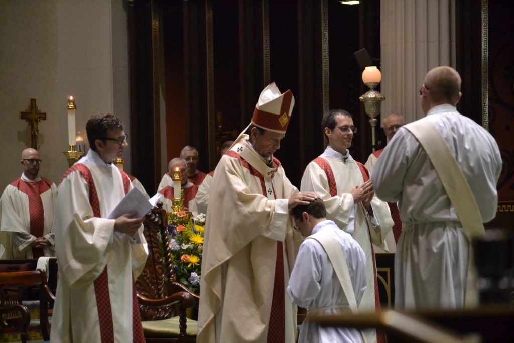 Archbishop Schnurr lays his hands on the head of Peter Langenkamp in silence in the Laying on of Hands (CT Photo/Greg Hartman)