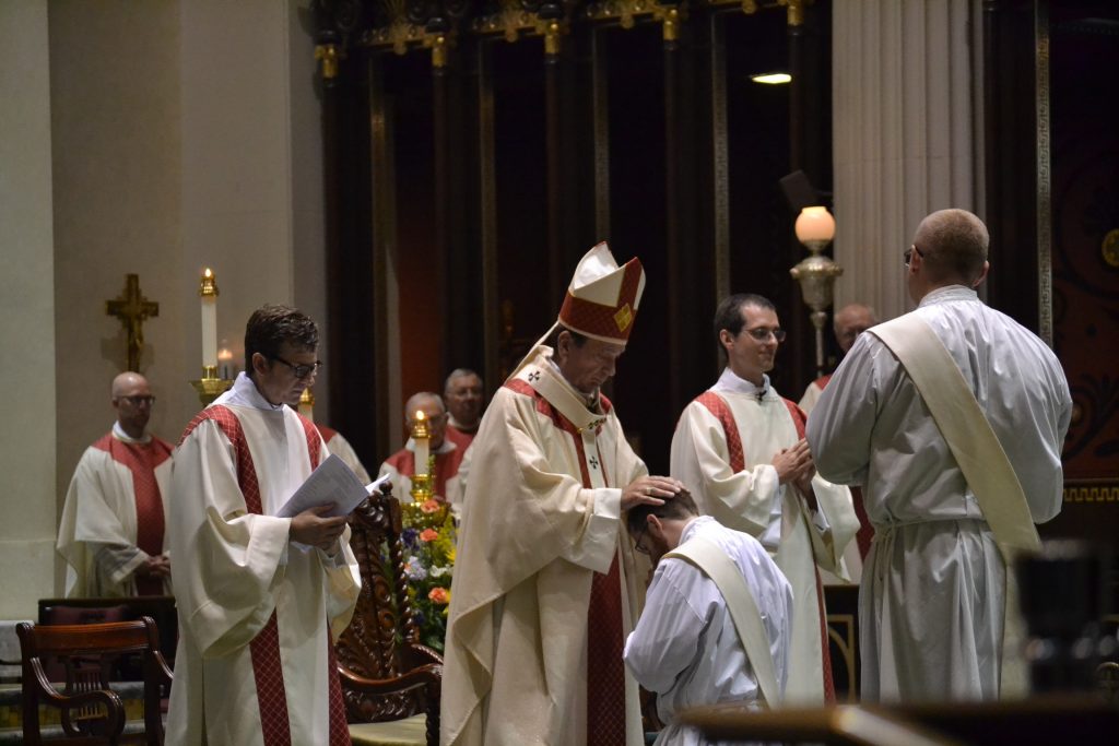 Archbishop Schnurr lays his hands on the head of Alexander Witt in silence in the Laying on of Hands (CT Photo/Greg Hartman)