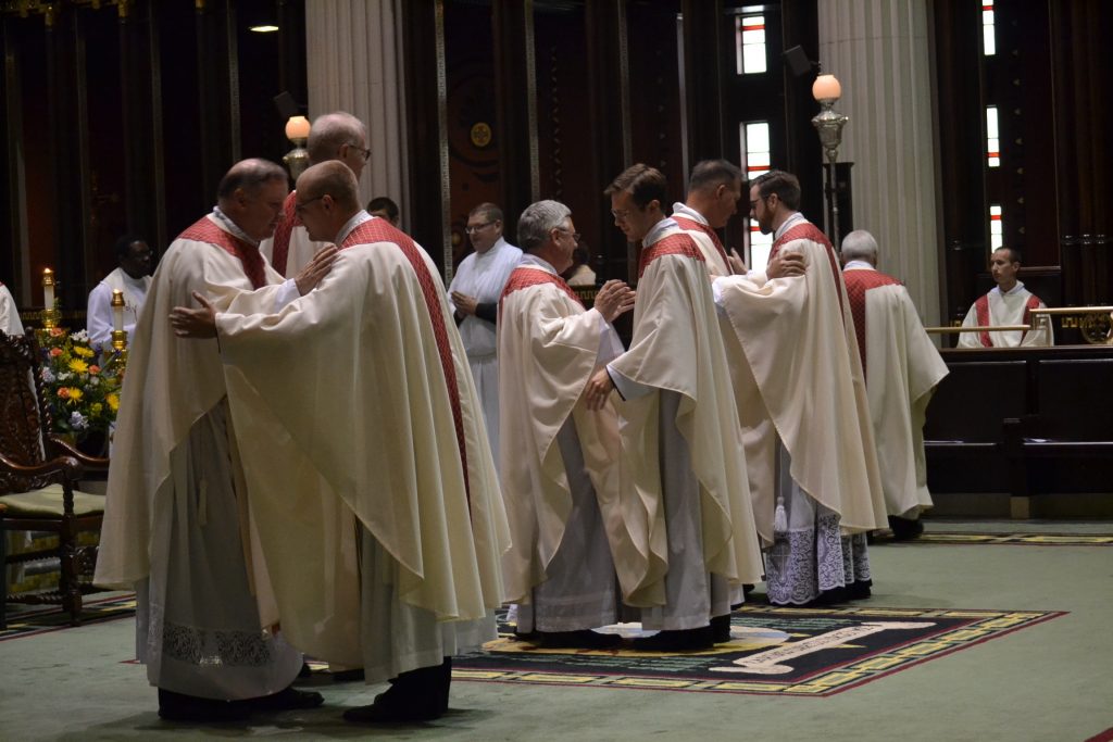 The priests in the sanctuary welcome the newly ordained into the order of presbyters (CT Photo/Greg Hartman)