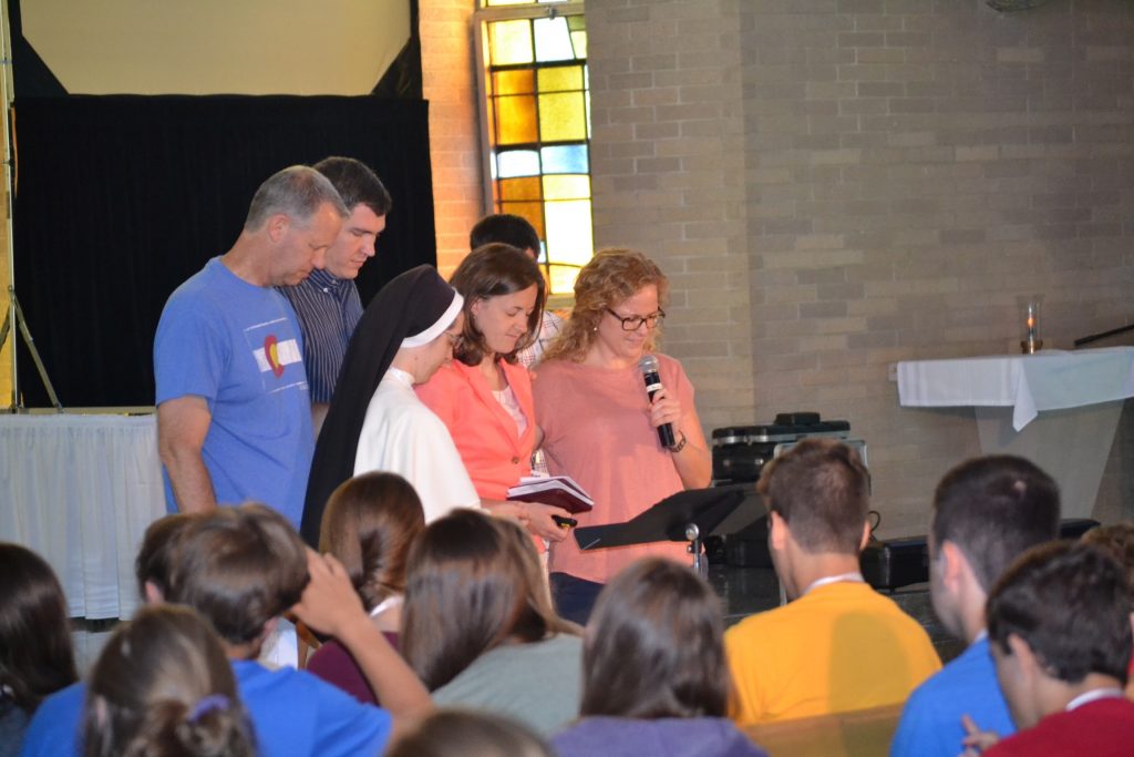 The team prays over the morning keynote speaker Jacquie Lustig. (CT Photo/Greg Hartman)