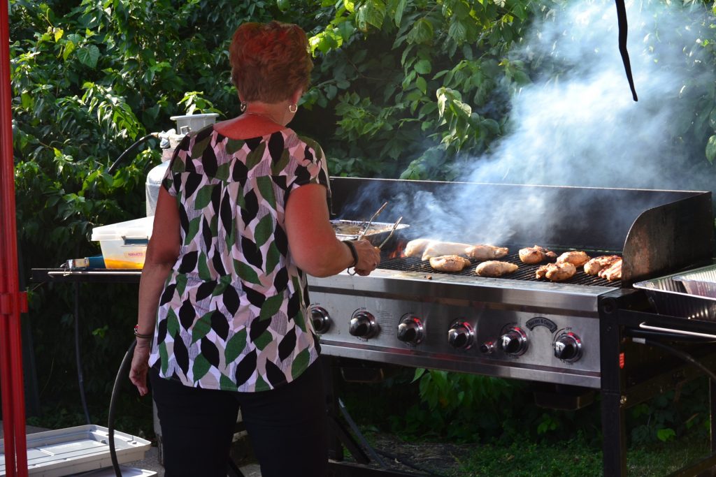 Among many delicious menu items at Gertie's Grill, volunteer readies the chicken. (CT Photo/Greg Hartman)