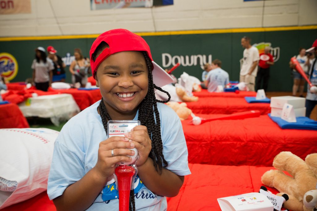 Grinning from ear to ear, a girl shows her Reds cap and new whiffle ball and bat. (Courtesy Photo)