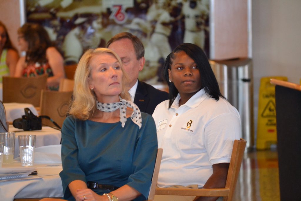 CISE Student Tionna Jordan from Roger Bacon is seated with Jill Meyer after her address to the crowd on her journey in Catholic Schools. (CT Photo/Greg Hartman)