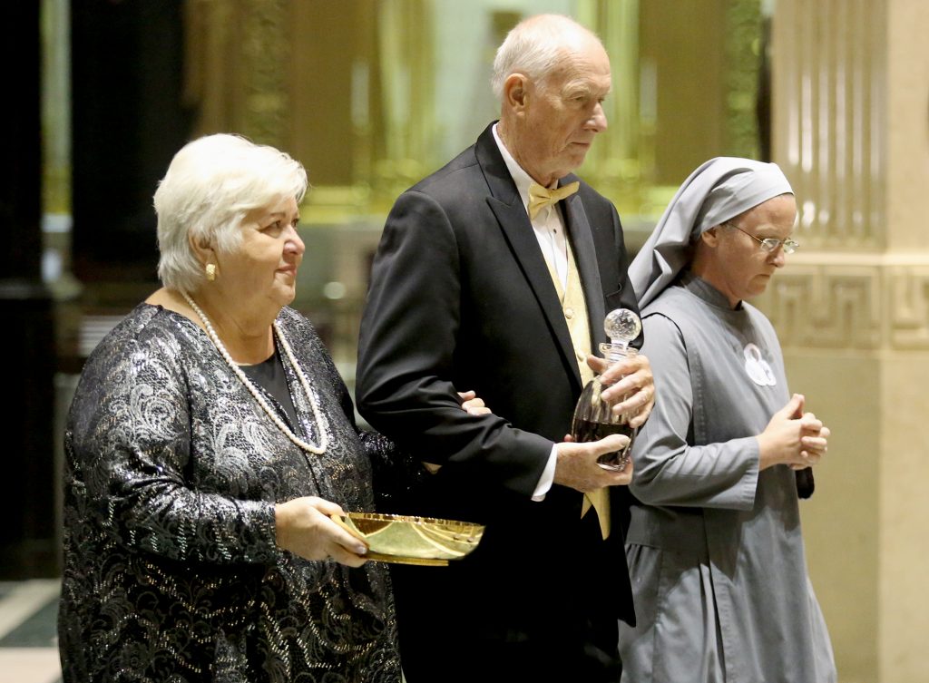 Gert and Gerry Patterson bring up the offertory gifts during the Golden Jubilee Mass at the cathedral accompanied by their daughter, Sister Mary Mediatrix of All Grace, a member of the Society of Our Lady of the Most Holy Trinity. (CT Photo/E L Hubbard)