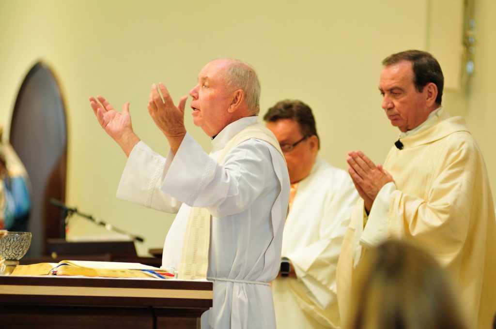 The pastor, Father Jim Manning, prays with Archbishop Dennis J. Schnurr at the Mass celebrating the parish’s 150th anniversary and the new church building’s first anniversary. (CT Photo/Jeff Unroe)