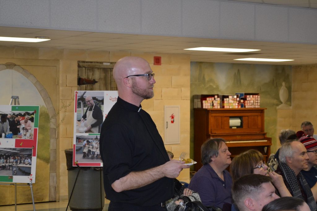 Though he was on The Great American Baking Show, Father Kyle watches with those gathered the outcome in the first episode. (CT Photo/Greg Hartman)