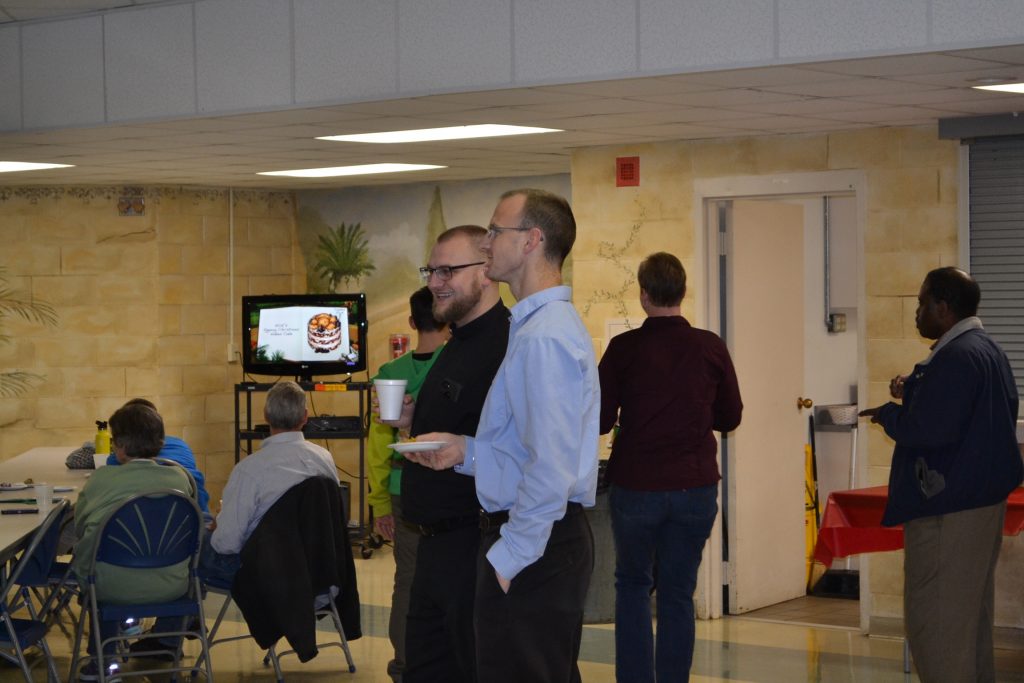 From the Vocations Office, Wayne Topp watches the former Director of the Vocations Office. (CT Photo/Greg Hartman)