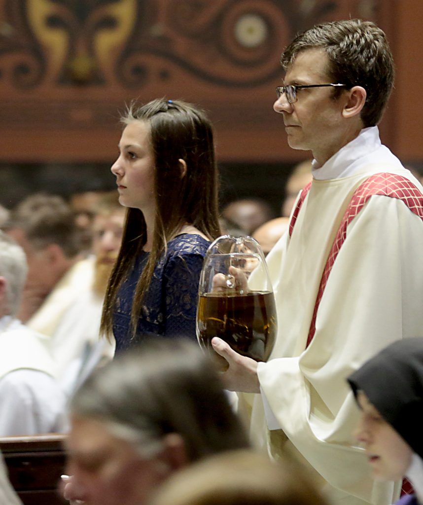 Hope Cromer and Deacon Craig Best present the Sacred Chrism Oil during the Chrism Mass at the Cathedral of Saint Peter in Chains in Cincinnati Tuesday, Mar. 27, 2018. (CT Photo/E.L. Hubbard)