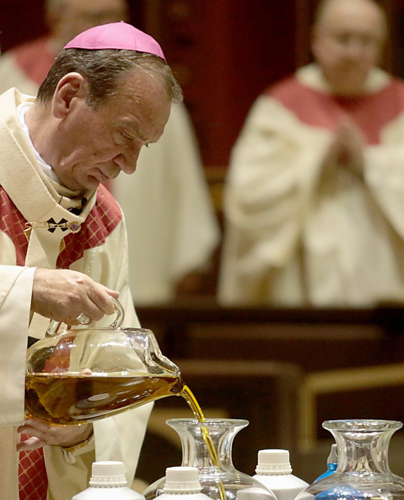 Archbishop Dennis Schnurr pours the Sacred Chrism Oil during the Chrism Mass at the Cathedral of Saint Peter in Chains in Cincinnati Tuesday, Mar. 27, 2018. (CT Photo/E.L. Hubbard)