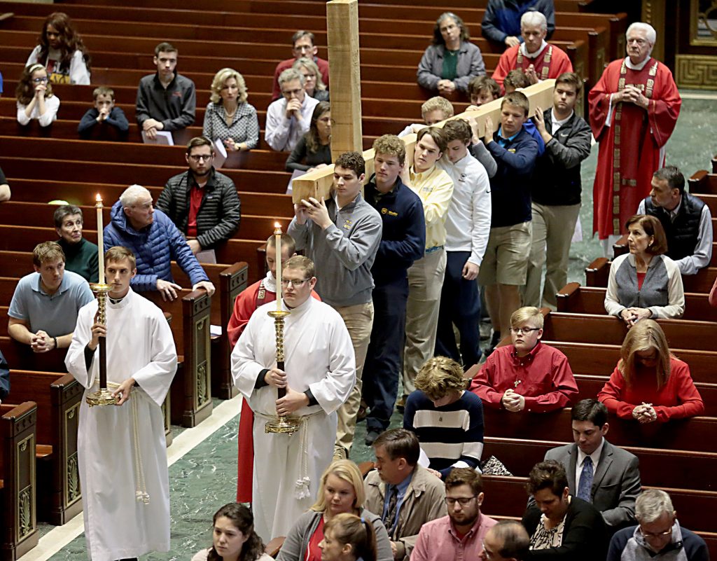 Students from Cincinnati Moeller High School carry the Holy Cross for the Celebration of the Passion of the Lord at the Cathedral of St. Peter in Chains in Cincinnati on Good Friday, Mar. 30, 2018. (CT Photo/E.L. Hubbard)