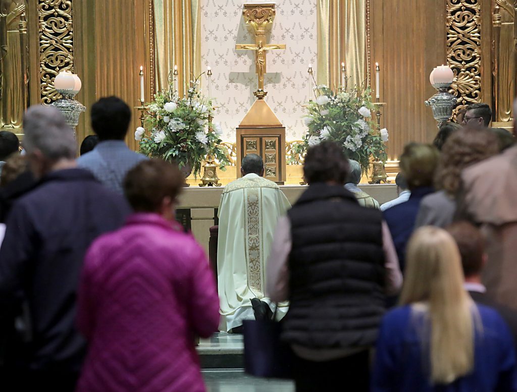 Archbishop Dennis Schnurr and Concelebrant Priests kneel before the Altar after the Transfer of the Most Blessed (CT Photo/E.L. Hubbard)