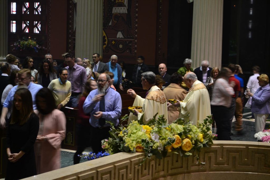 Bishop Joseph Binzer and Rev. Raymond Larger distribute communion on Easter Sunday, April 1, 2018. (CT Photo/Greg Hartman)