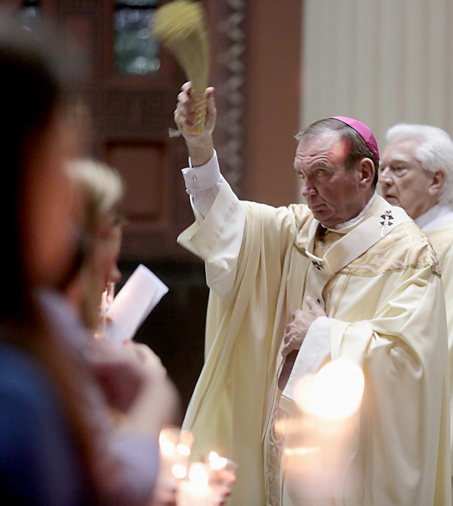Archbishop Dennis Schnurr, with Deacon David Klingshirn, blesses the church with Holy Water for the Easter Vigil in the Holy Night at the Cathedral of Saint Peter in Chains in Cincinnati, Holy Saturday, March 31, 2018. (CT Photo/E.L. Hubbard)