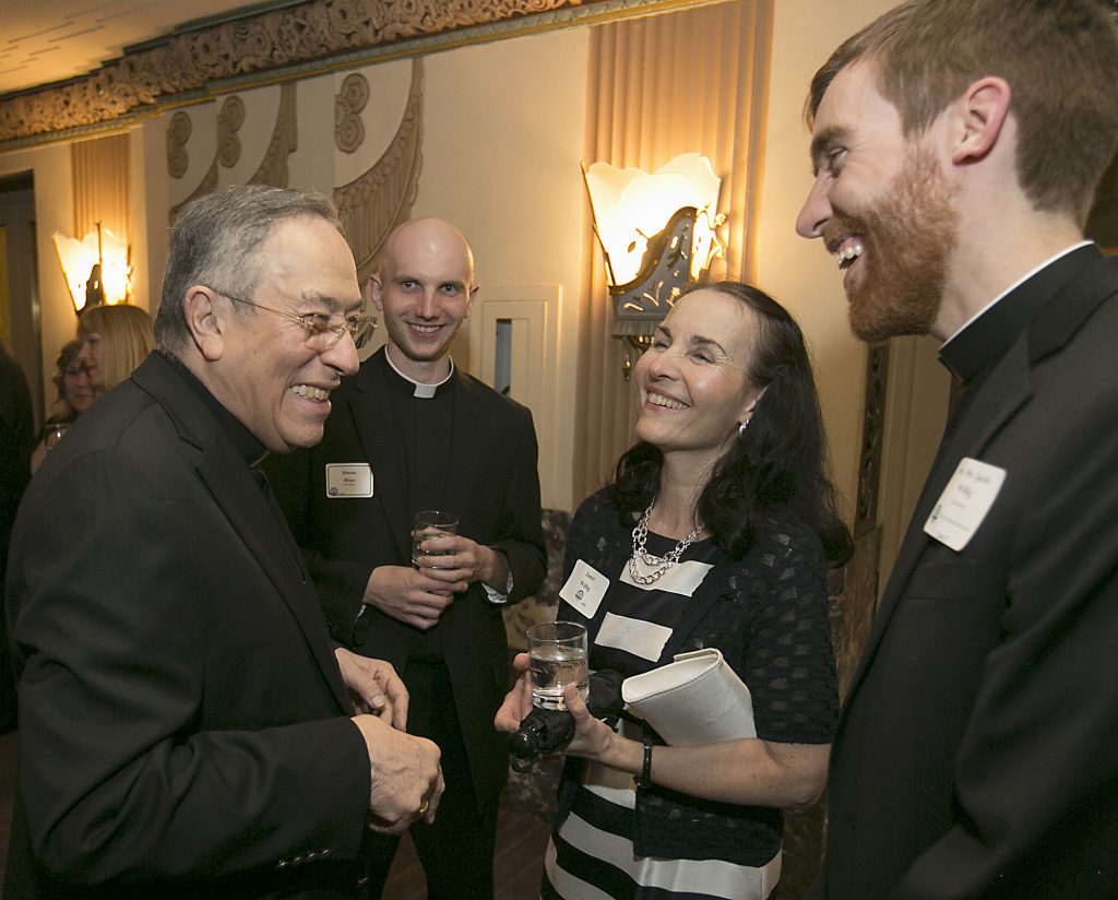 Oscar Cardinal Rodriguez Maradiaga, of Honduras, shares a laugh with seminarian Simon Mino, Janet Willig, and Deacon Joseph Willig during the Bishop Fenwick Society dinner at the Hilton Cincinnati Netherland Plaza Hotel Friday, May 4, 2018. (CT Photo/E L Hubbard)