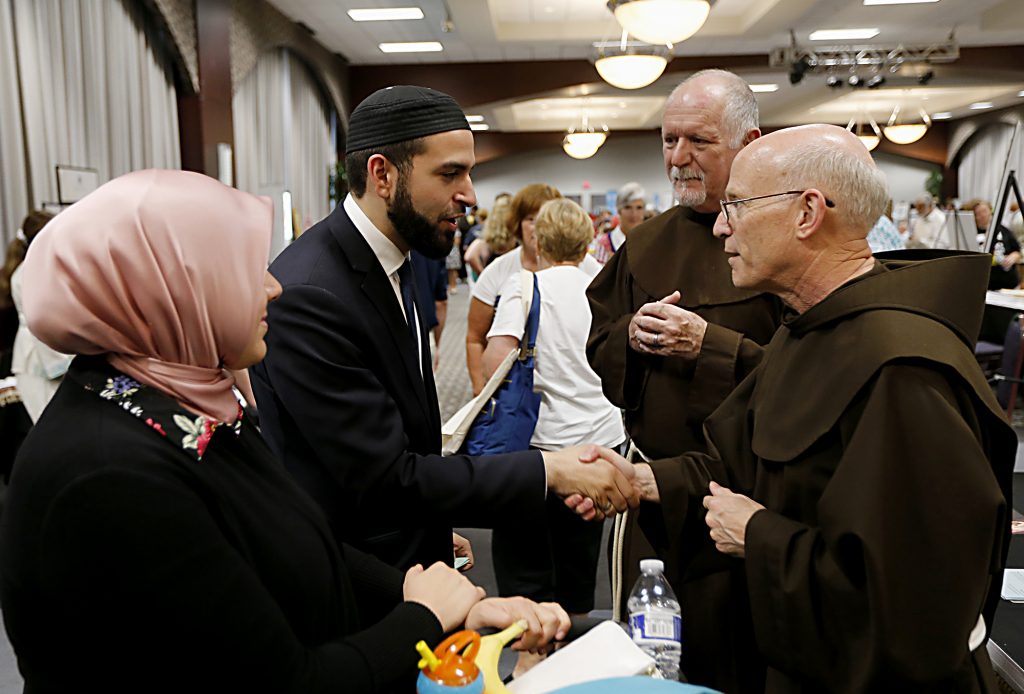 Jasnim Salem and her husband, Jammam Alwan, members of the Islamic Center of Greater Cincinnati, chat with Brother Timothy Lamb, OFM, and Father Bill Farris, OFM, during the first Festival of Faiths at the Cintas Center in Cincinnati Sunday, June 24, 2018. (CT Photo/E.L. Hubbard)