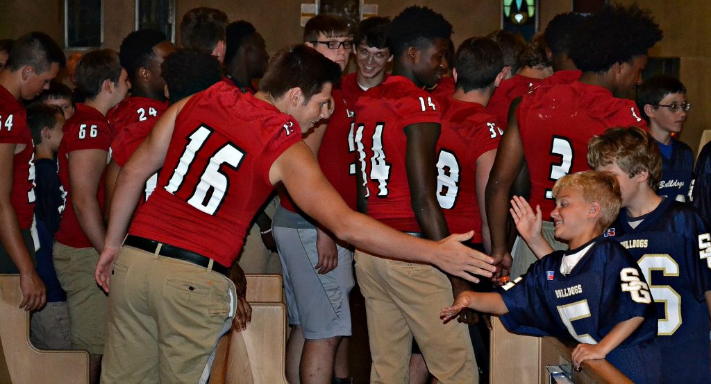 After the rosary, some of the La Salle Football Team shake hands and high five players from the St. Gertrude Football Team (CT Photo/Greg Hartman)