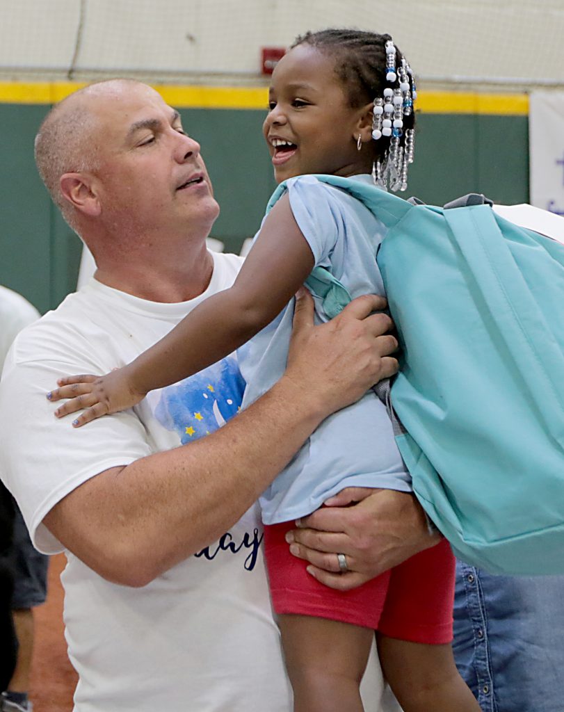 Volunteer Steve Rowland lifts up Khalimah Bowens during the second annual “Day to Dream” event at the P&G MLB Cincinnati Reds Youth Academy in Roselawn Saturday, Aug. 25, 2018. St. Vincent de Paul - Cincinnati and Morris Furniture Company teamed up to provide 50 children in need with a bed of their own. (CT Photo/E.L. Hubbard)