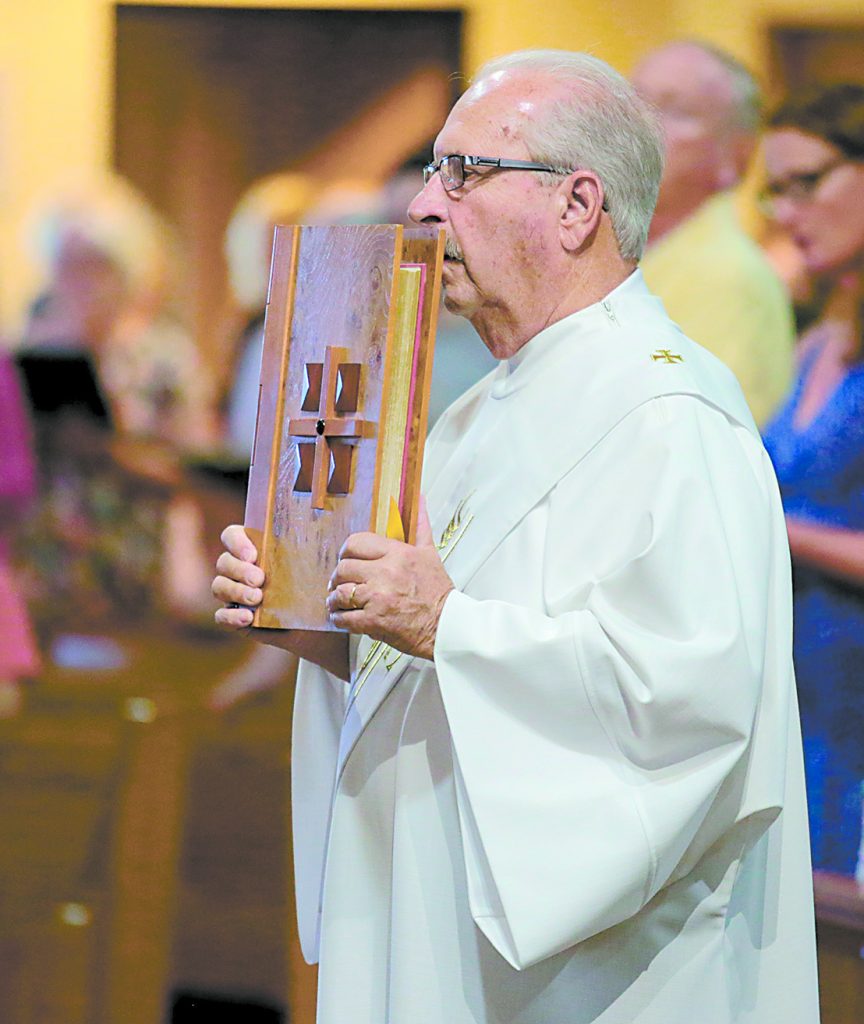 Deacon Bill Brunsman carries the Holy Bible during the processional for the St. Aloysius Parish 150th Anniversary Mass in Shandon Saturday, June 2, 2018. (CT Photo/E.L. Hubbard)