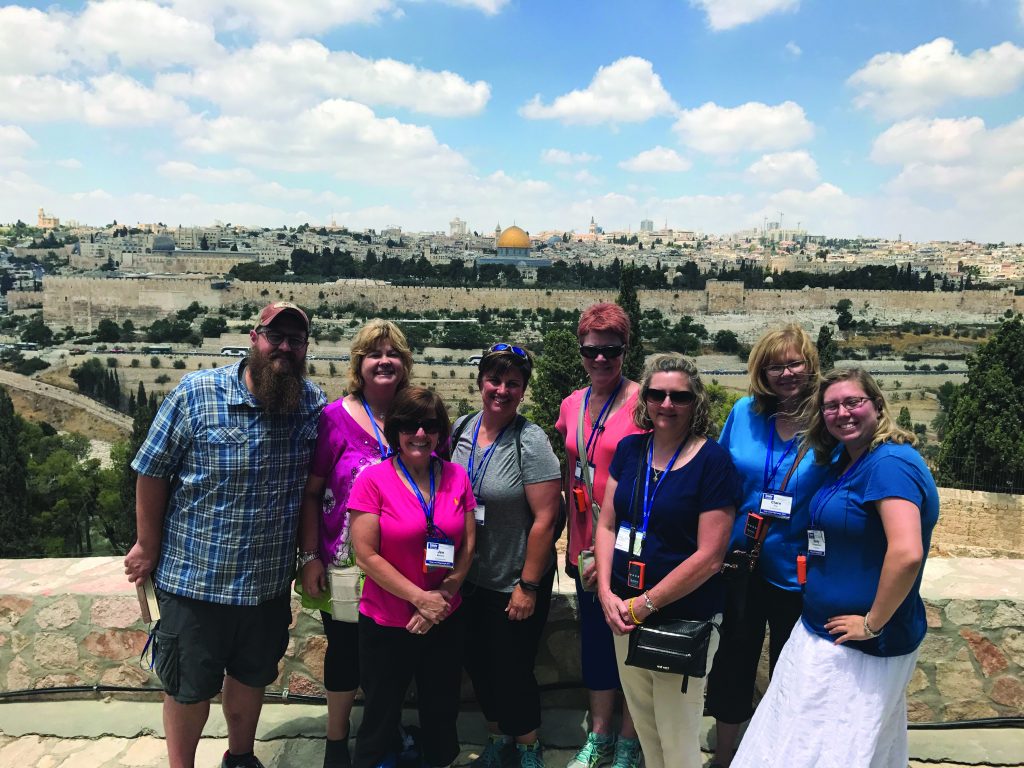 John Leyendecker poses with St. James staff members in 2017 with Jerusalem in the background. Pictured from left are Leyendecker, Melissa Spainhower, Jen Meiners, Karen Wiesman, Sherry Kembre, Carol Feldman, Clare Fox and Emily Ramsey. (Courtesy Photo)