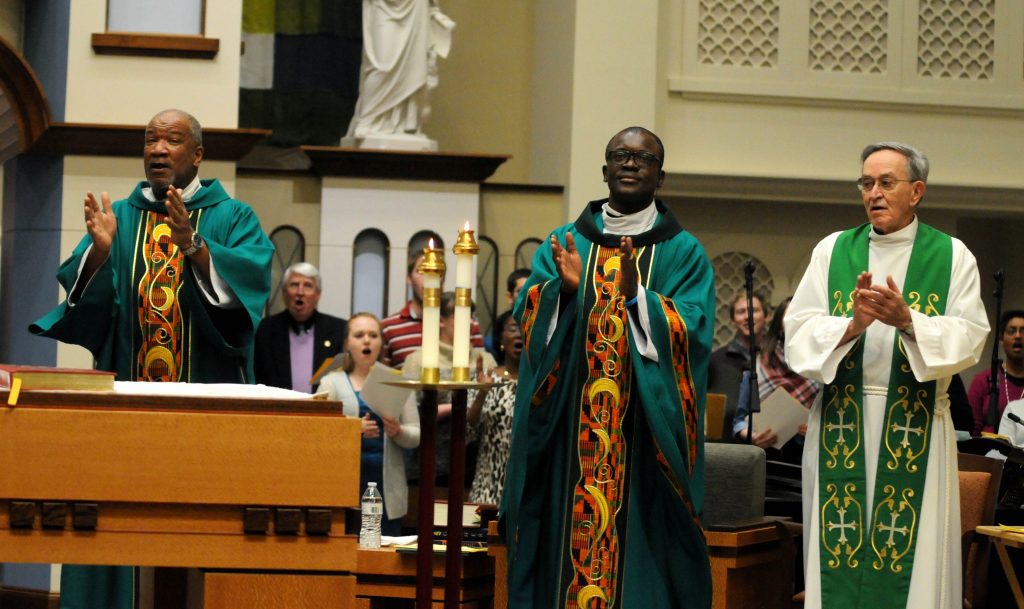 Rev. Mr. Royce Winters(cq), Father Asibou Kuci(cq) and Father Ted Cassidy(cq) clap along with the congregation during the "Gathering Hymn" of the University of Dayton's "Mass in Celebration of Black History Month" in the Chapel of the Immaculate Conception on Sunday, Feb. 10. (CT Photo/David Moodie)