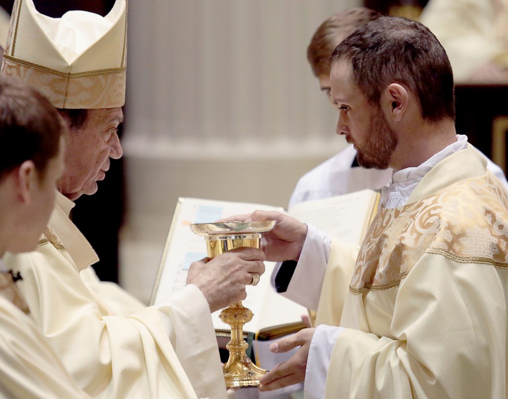 Father Jedidiah Tritle receives the chalice and paten. (CT Photo/E L Hubbard)