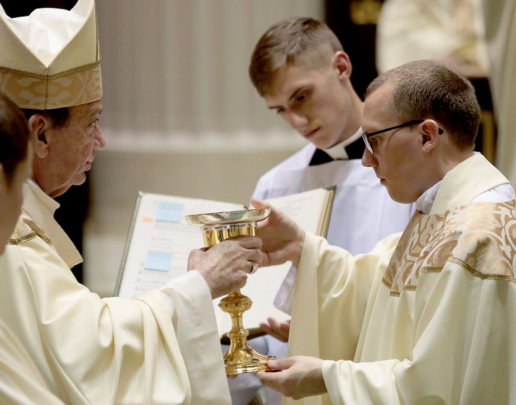 Father Jeffrey Stegbauer receives the chalice and paten. (CT Photo/E L Hubbard)