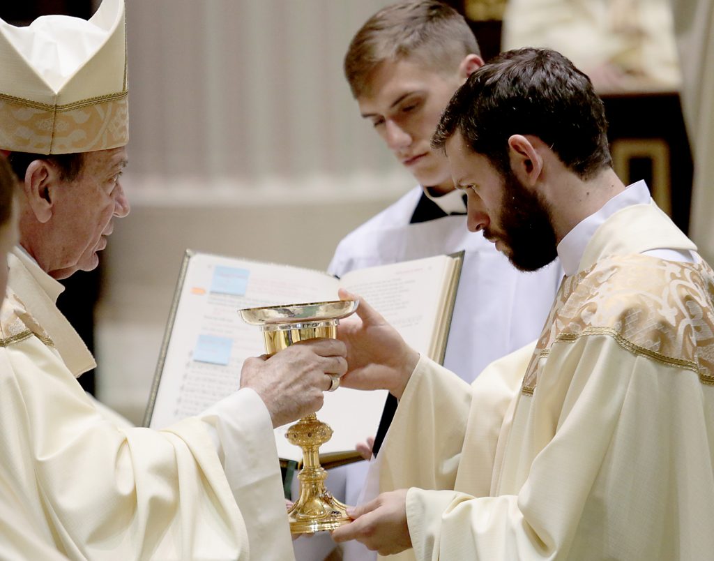 Father Ambrose Dobrozsi receives the chalice and paten. (CT Photo/E L Hubbard)