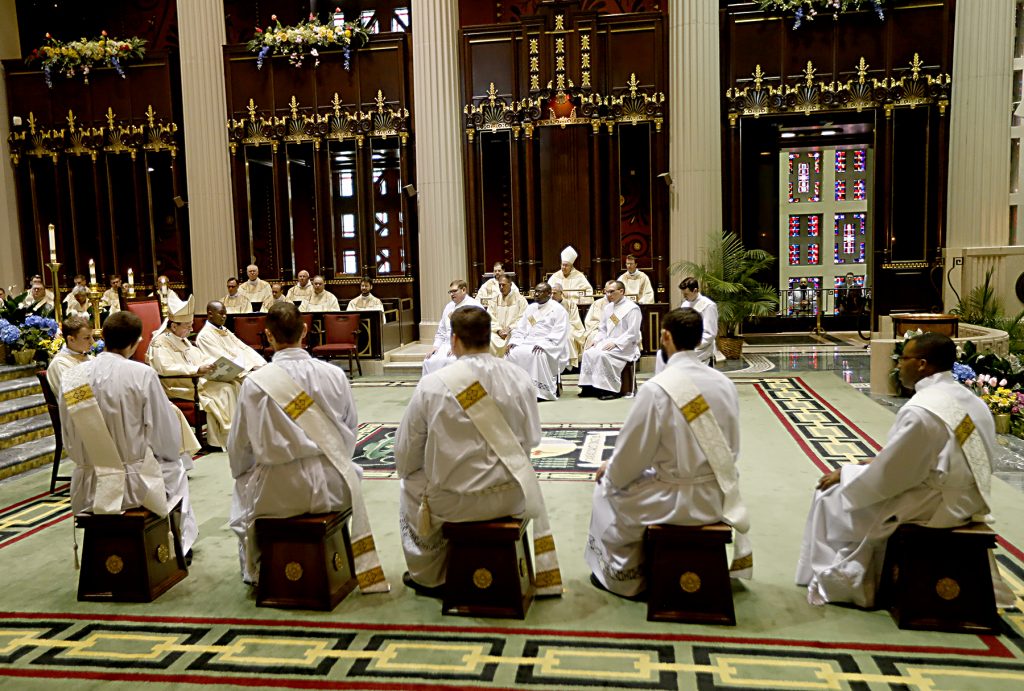 The ordinands listen to the homily from Archbishop Dennis Schnurr. (CT Photo/E L Hubbard)