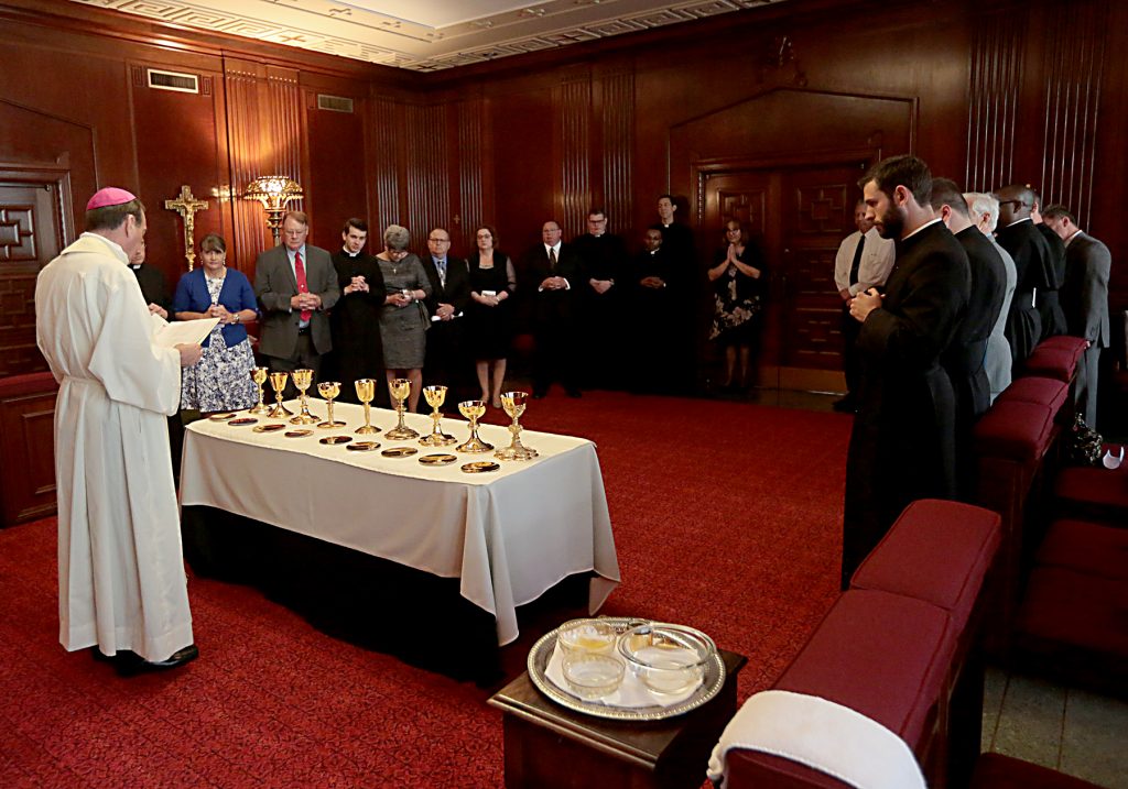 Archbishop Dennis Schnurr blesses the newly ordained chalices and patens prior to the beginning of Mass. (CT Photo/E L Hubbard)